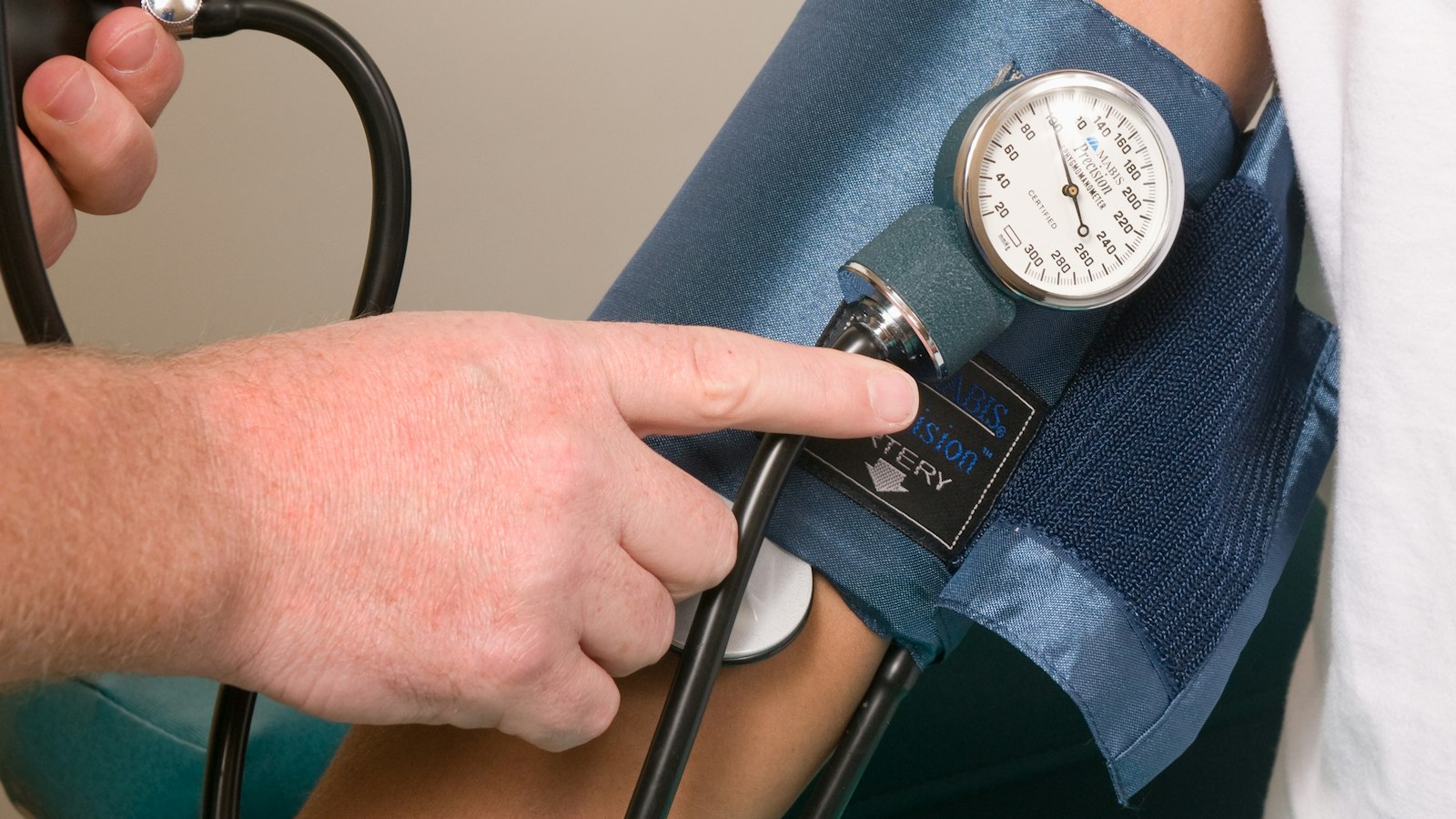 Doctor measuring a patient's blood pressure with a cuff and gauge